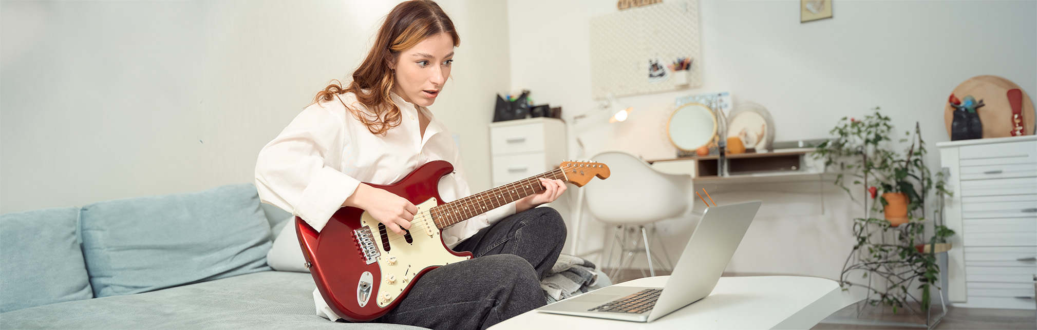 Étudiante apprenant à jouer de la guitare [Featured]