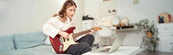 Estudiante aprendiendo a tocar la guitarra [Featured]